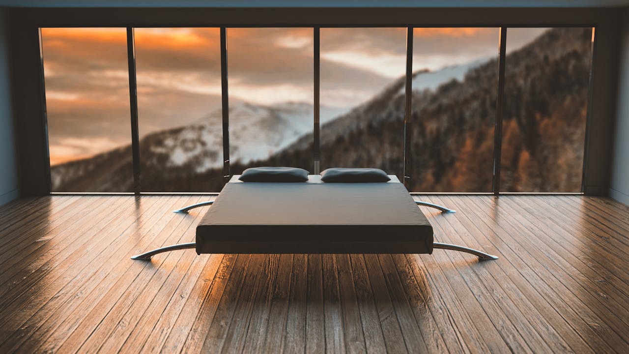 collection-01 Minimalist bedroom with large windows offering a breathtaking mountain view during sunset.