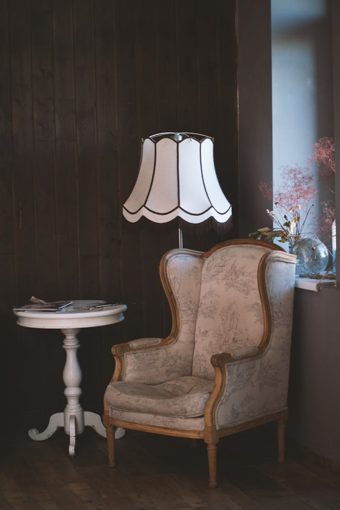 collection-03 Charming vintage interior with an armchair, elegant lamp, and side table. Perfect for cozy settings.