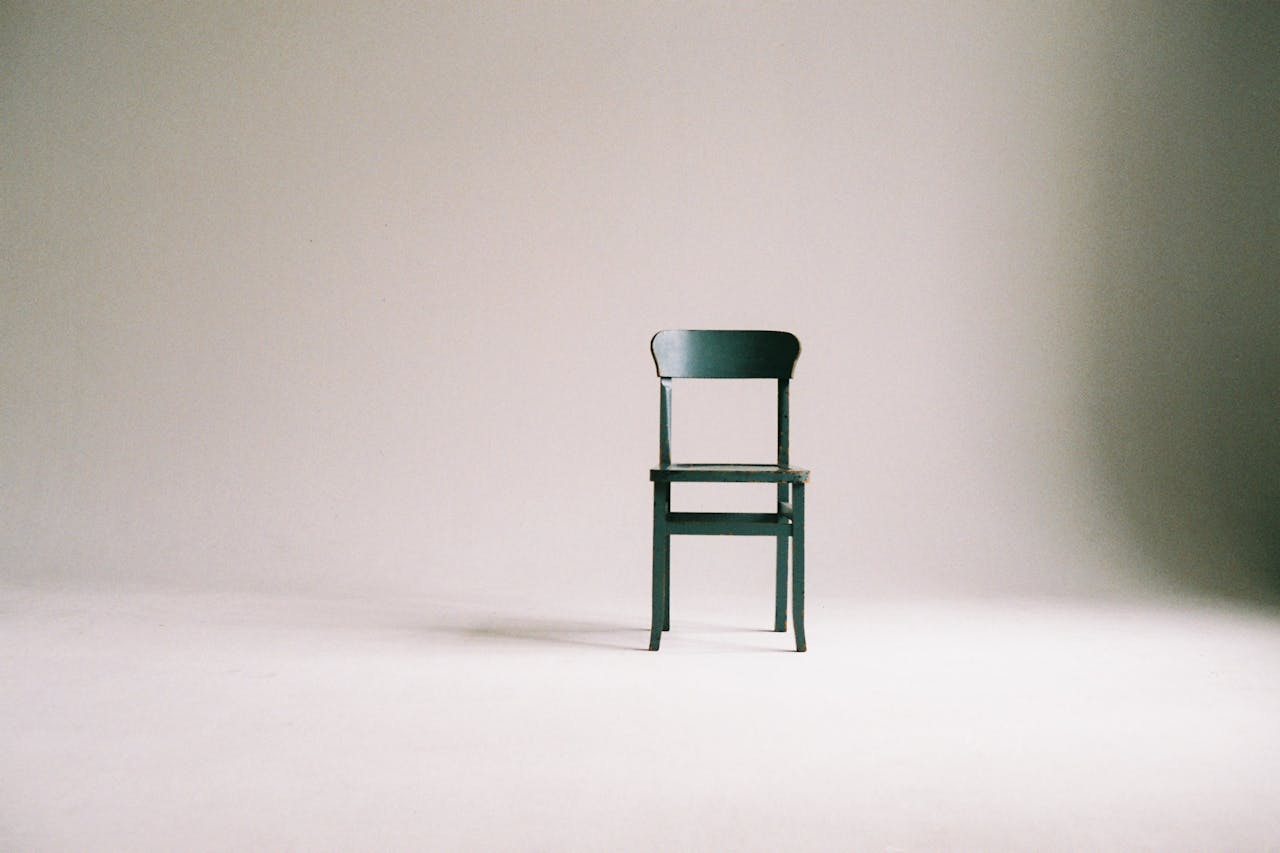 collection-04 A single black chair in a minimalistic studio setting with a neutral backdrop.